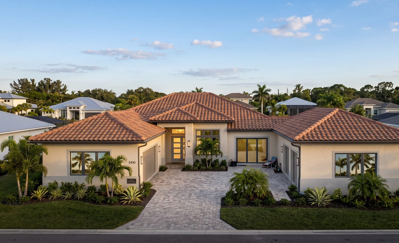 Completed custom home by Acosta Builders in Bradenton, FL — tile roof, stucco exterior, impact windows, and finished carpentry at golden hour
